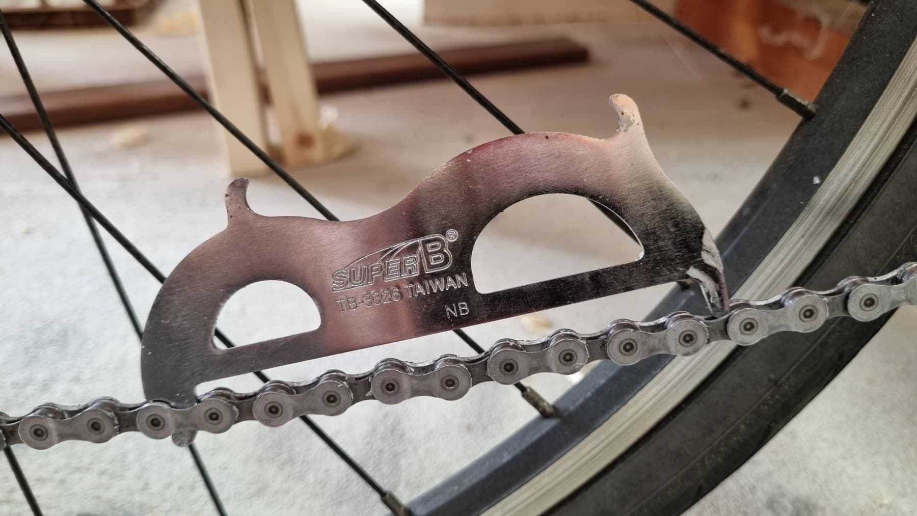 A drop-in gauge resting on a relatively unworn bicycle chain