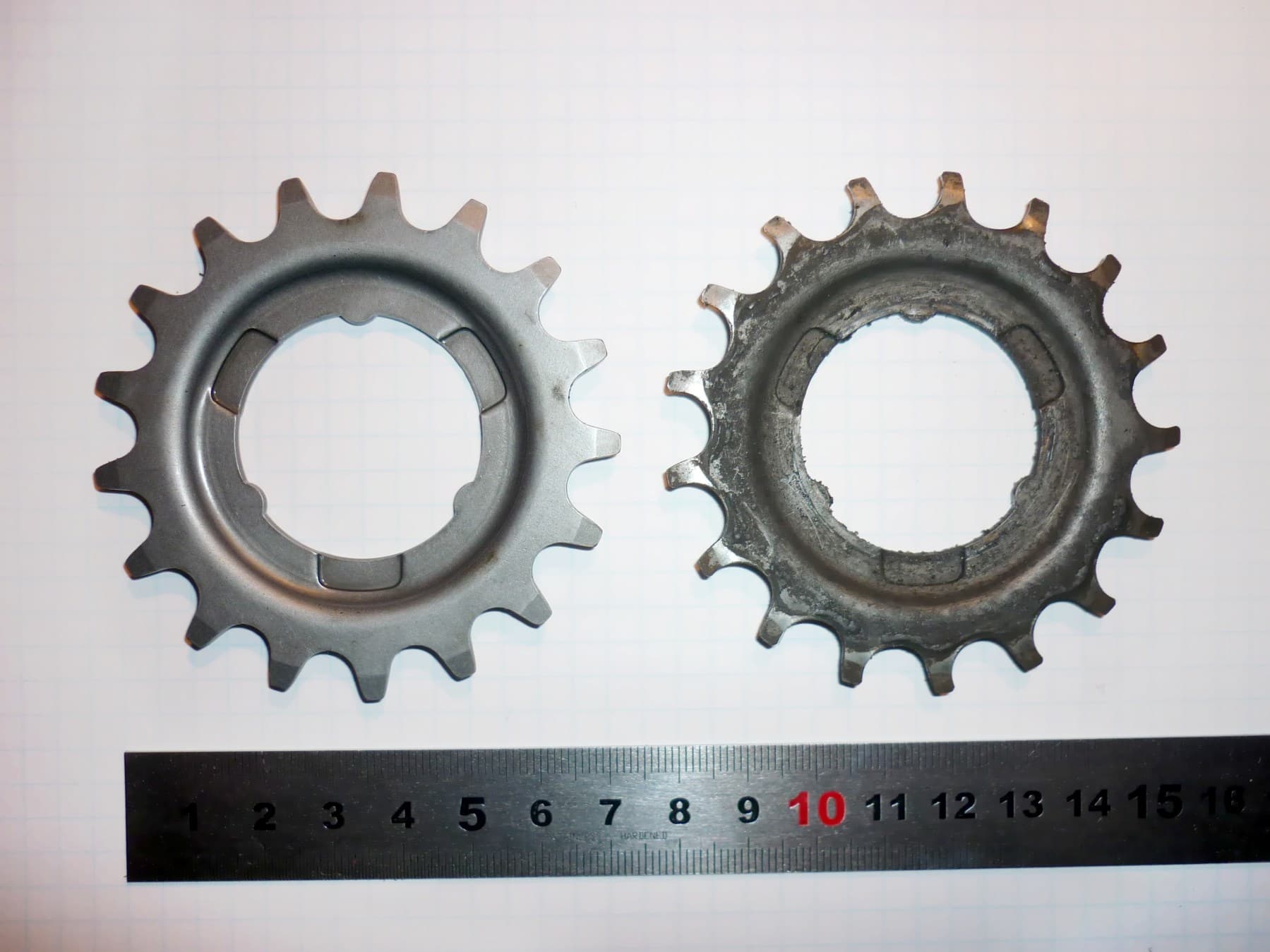 An unused rear sprocket beside a worn sprocket with visibly changed tooth profiles