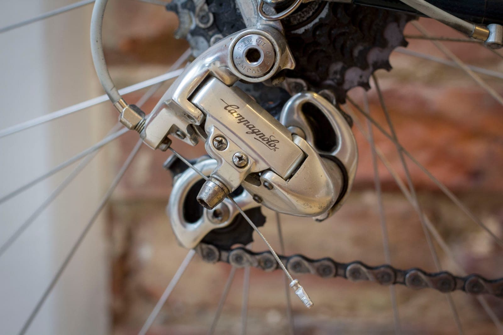 A mechanical rear derailleur showing the shift cable, housing, adjuster and fixing path