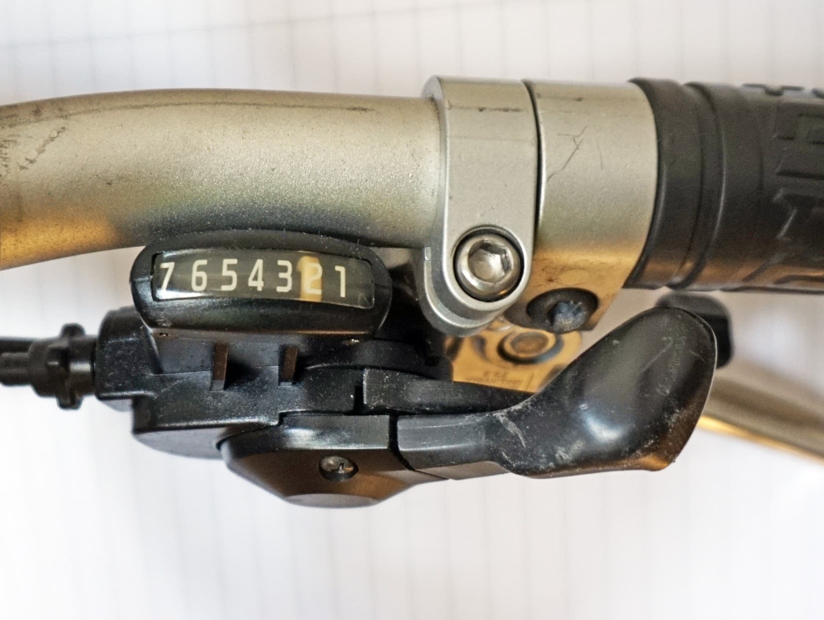 A real seven-position flat-bar bicycle trigger shifter with a gear indicator and cable adjuster