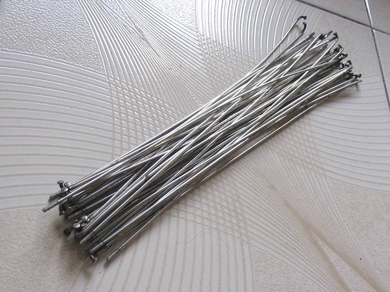 A real bundle of silver J-bend bicycle spokes with nipples