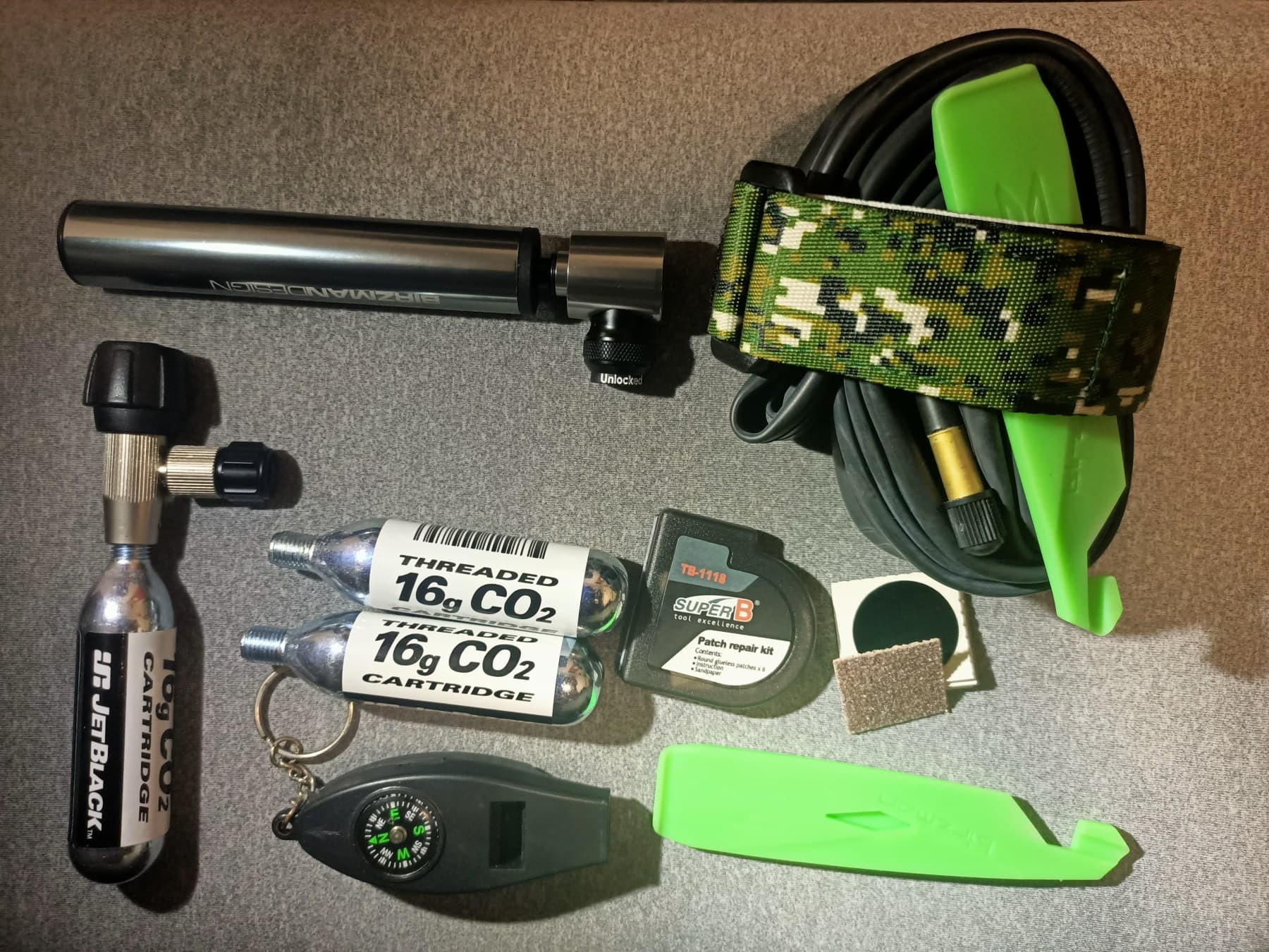 Bicycle flat-repair supplies including a spare tube, tire levers, patch, and pump