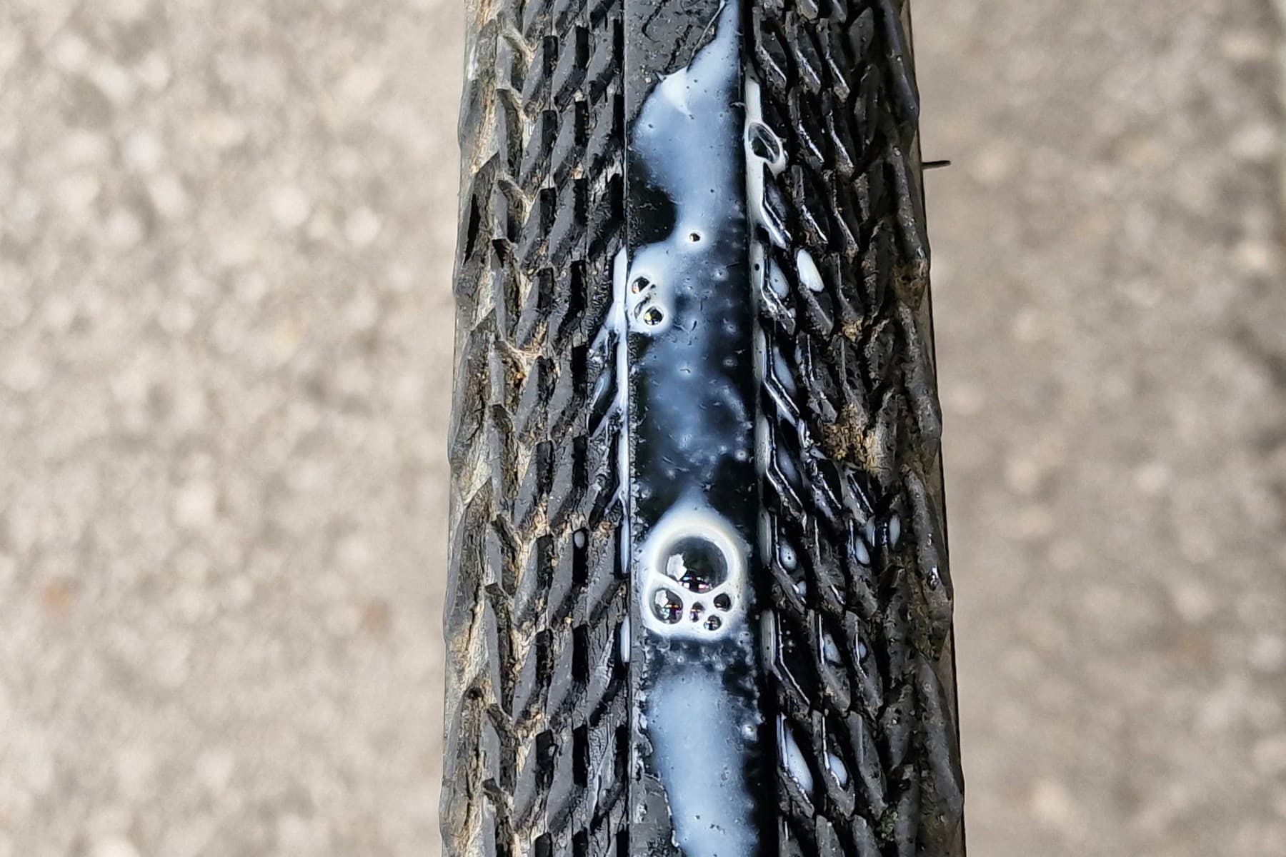Sealant bubbling from a puncture in a tubeless bicycle tire tread