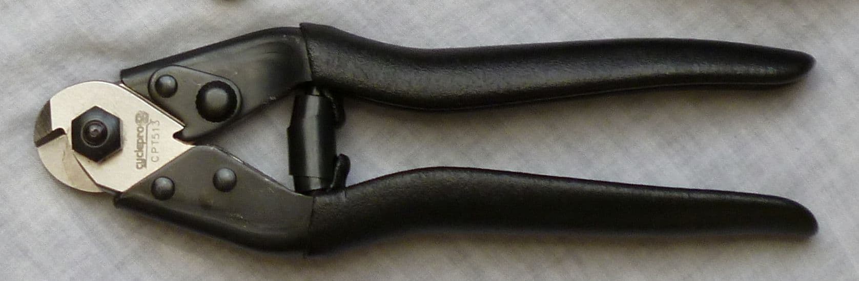 Cable cutters beside cut bicycle housing and inner cable