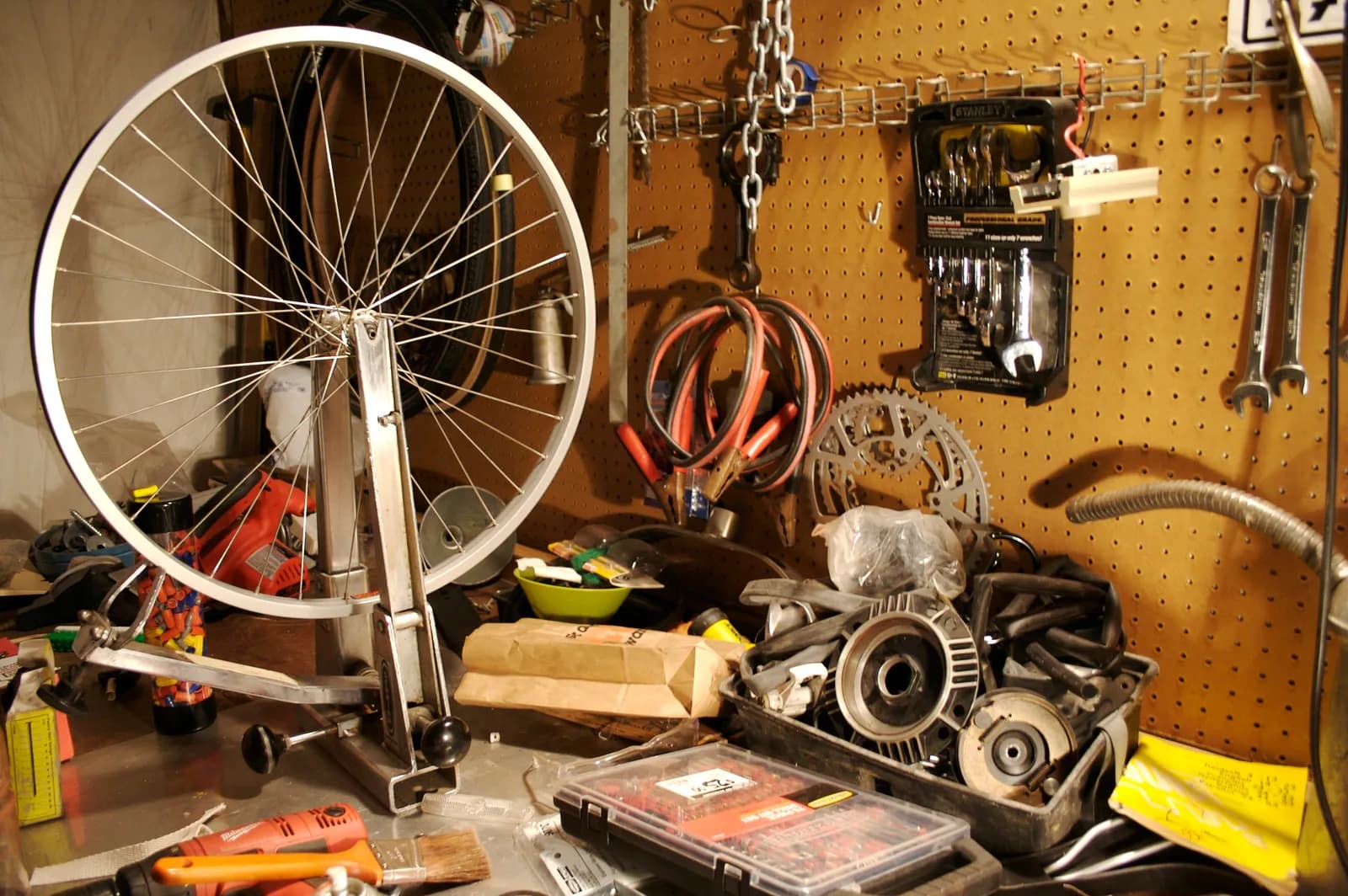 A bicycle wheel mounted in a truing stand on a workshop bench